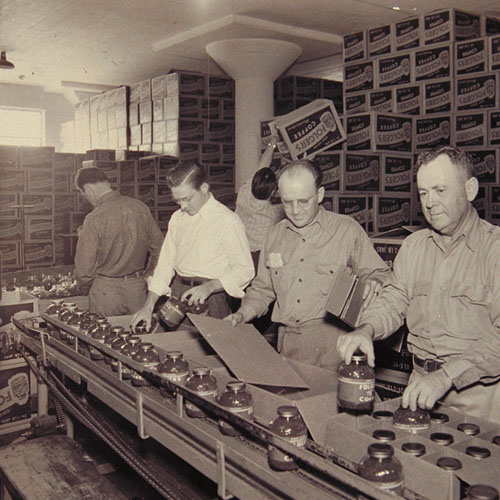 کارمندان کمپانی فولجرز در حال بسته بندی قوطی های قهوه